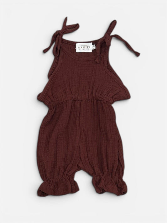 Organic brown cotton baby jumpsuit with tie shoulder straps and gathered legs.