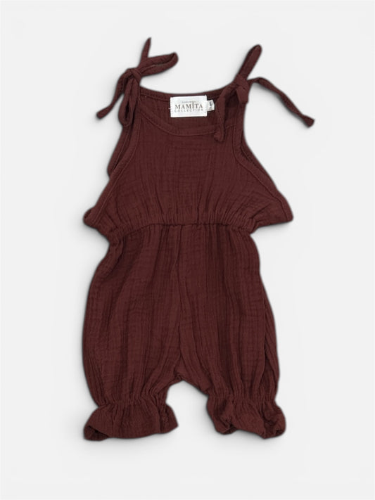 Organic brown cotton baby jumpsuit with tie shoulder straps and gathered legs.