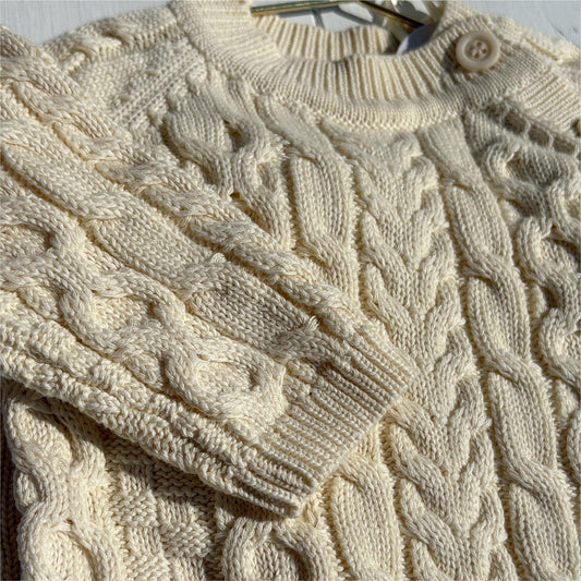 Cream cable knit baby sweater with soft organic cotton texture and button closure