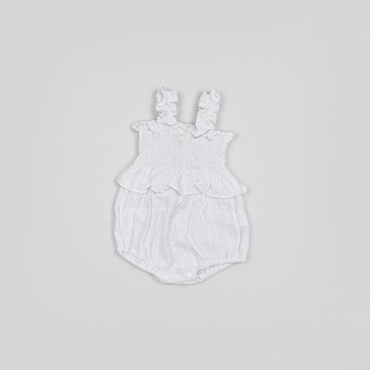Flat lay White baby romper with ruffled details on a gray background