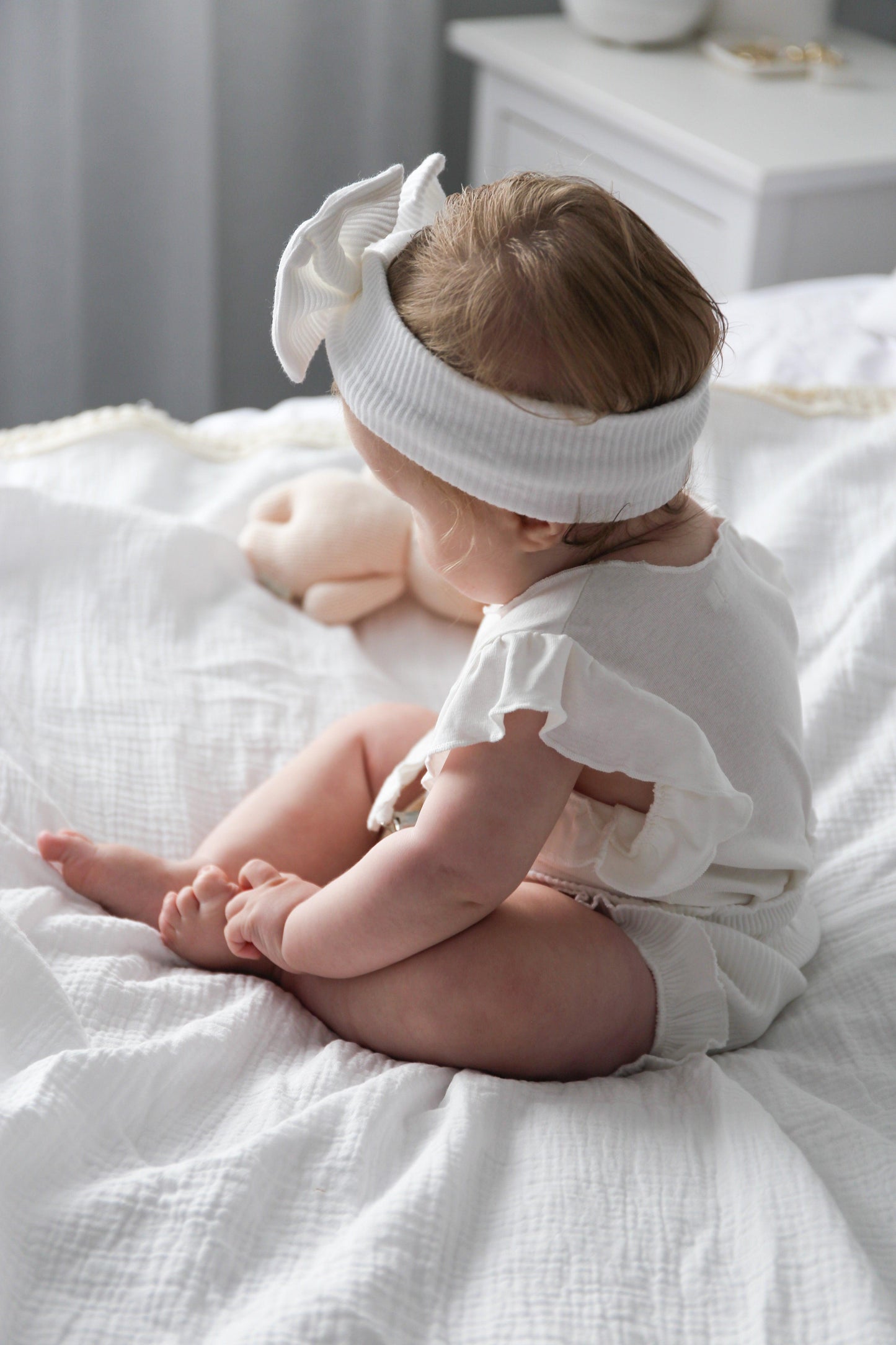 Organic white Mamīta Flure bodysuit on baby with ruffle sleeves and matching headband, Casita Bebes certified organic baby.