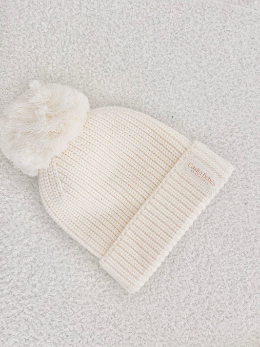 Cream organic cotton knitted baby beanie with pom-pom and folded cuff, certified organic.