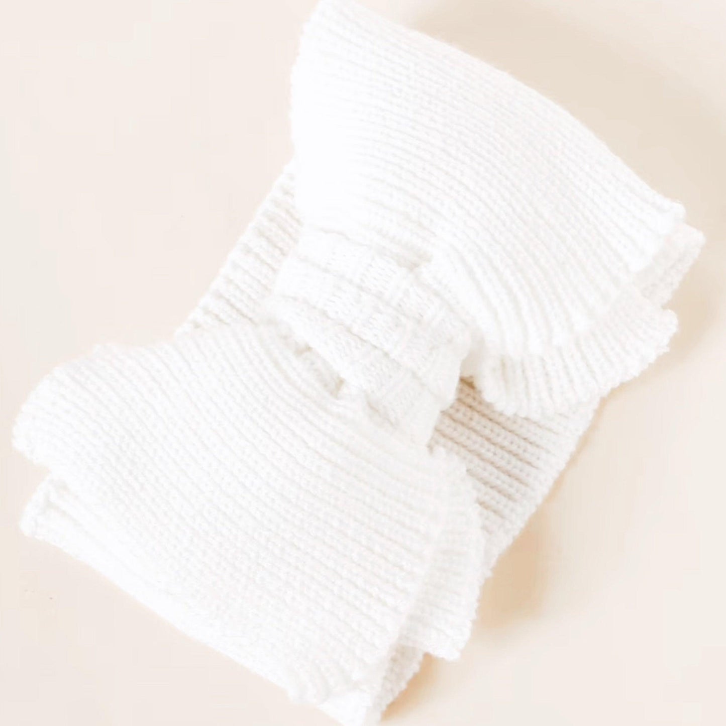 White organic knitted baby bow headband with ribbed texture, Casita Bebes certified organic baby clothing accessory.
