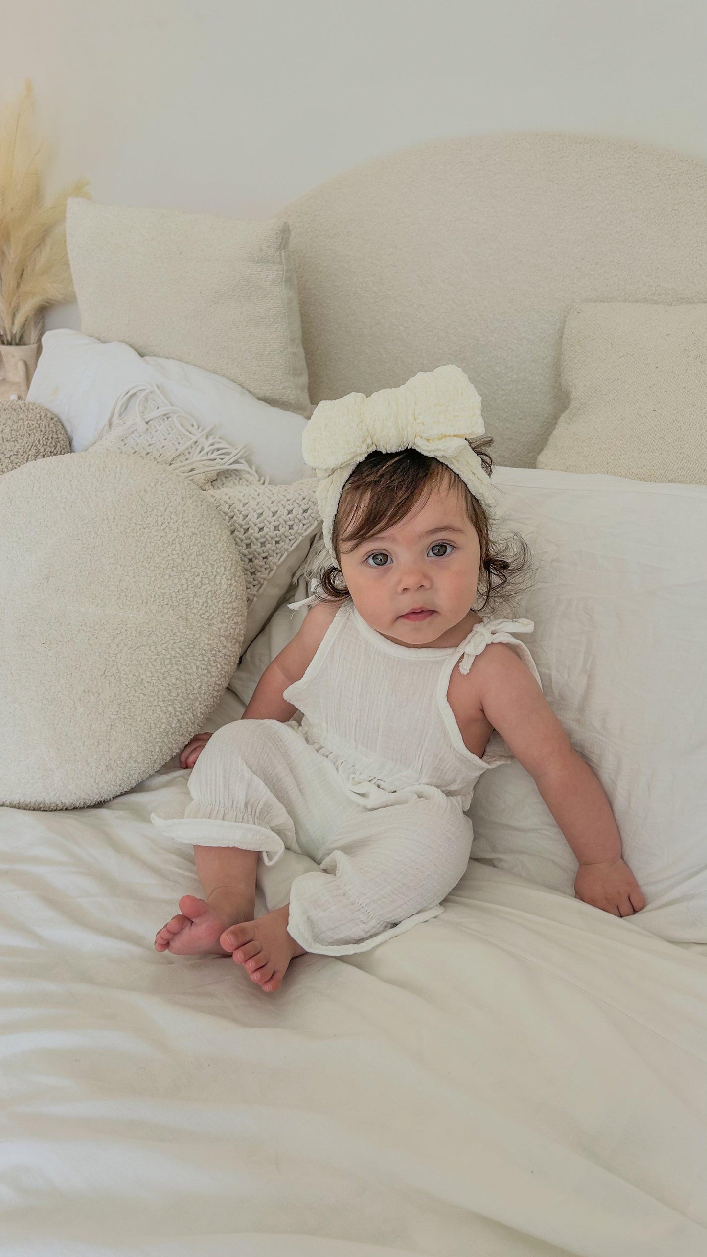 Organic white cotton jumpsuit with ruffle sleeves on baby, certified organic baby clothing from Casita Bebes.