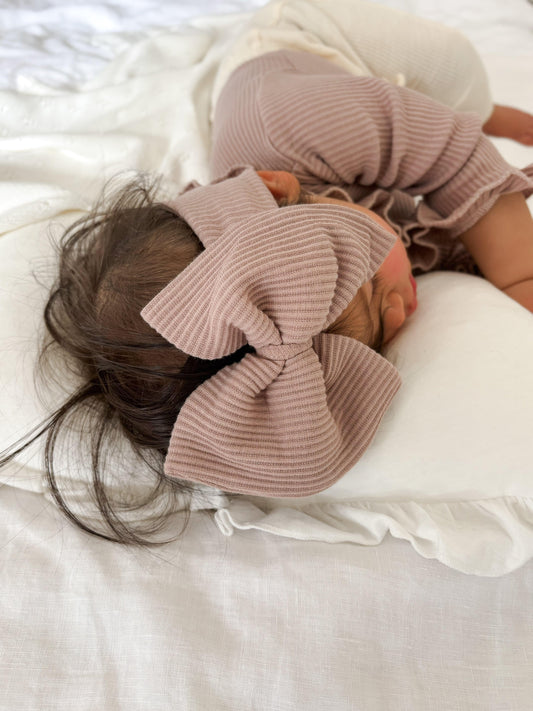Organic dusty pink ribbed baby bodysuit with matching bow, soft certified organic baby clothing from Casita Bebes.