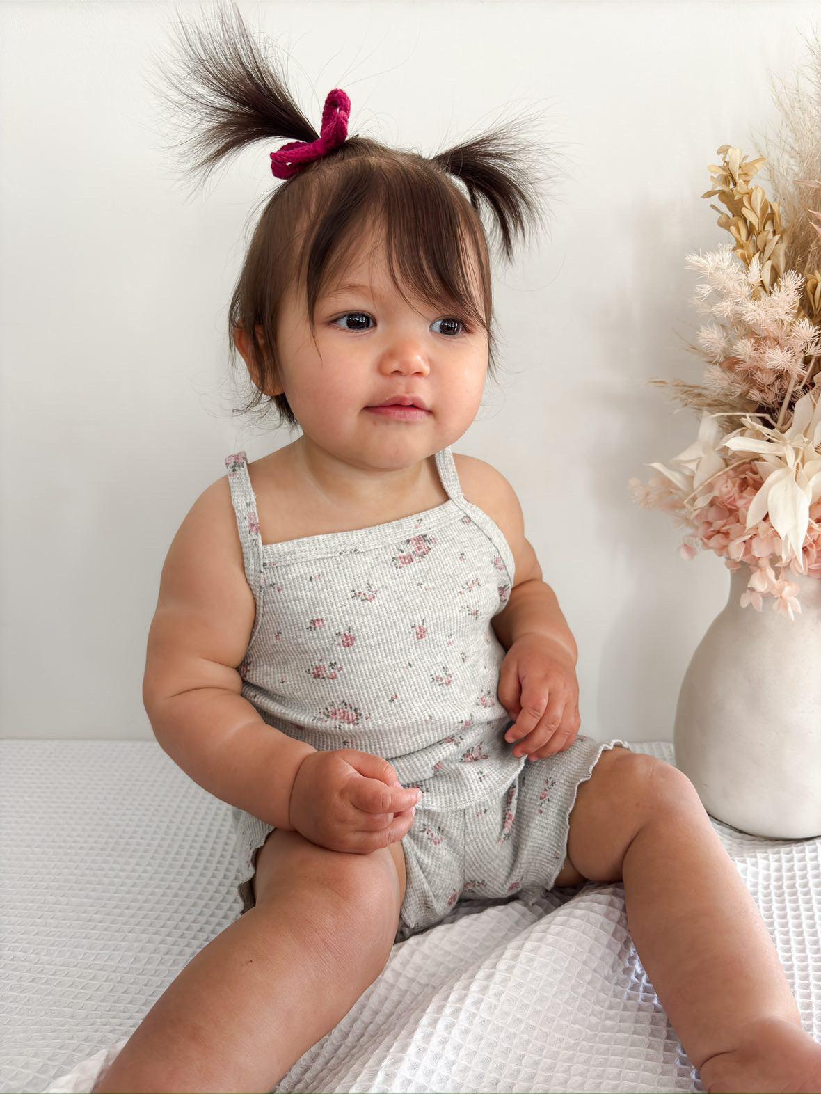 Organic certified baby girl wearing Mamīta Summer Sleepwear in light gray with small floral print by Casita Bebes.