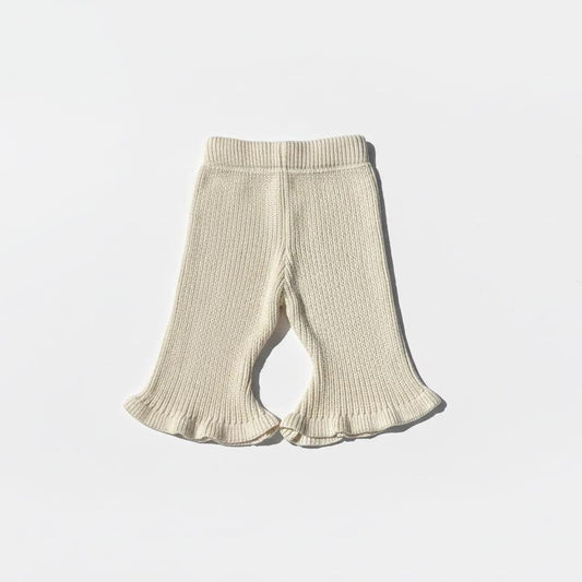 Beige organic knitted baby pants with flared ruffled hems from Mamita Collection.