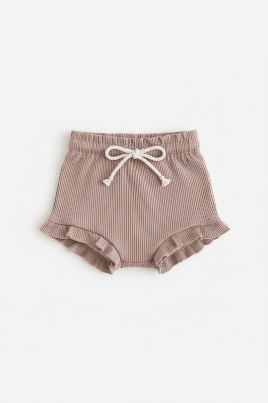 Soft ribbed baby bloomers with ruffled hem and drawstring waist, ideal for everyday comfort.
