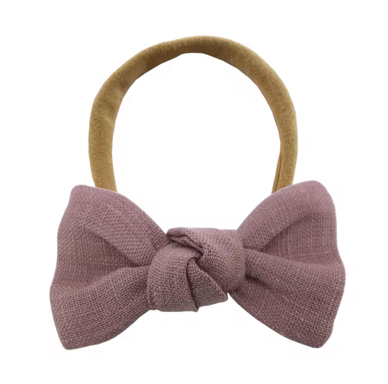 Soft organic baby headband with mauve bow, perfect for everyday essentials