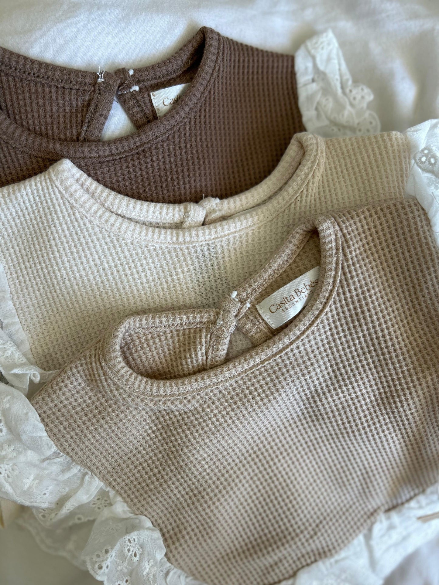 Organic baby waffle knit onesies with lace trim, soft neutral tones for everyday essentials