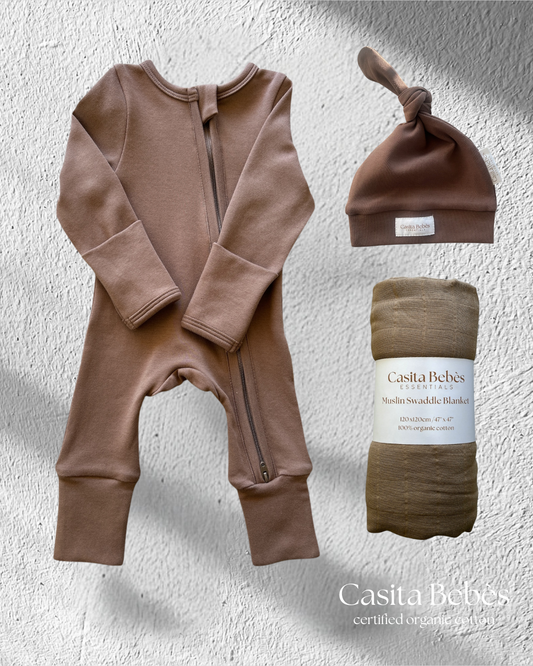 Baby onesie, hat, and swaddle blanket set with Casita Bebes branding on a textured gray background.