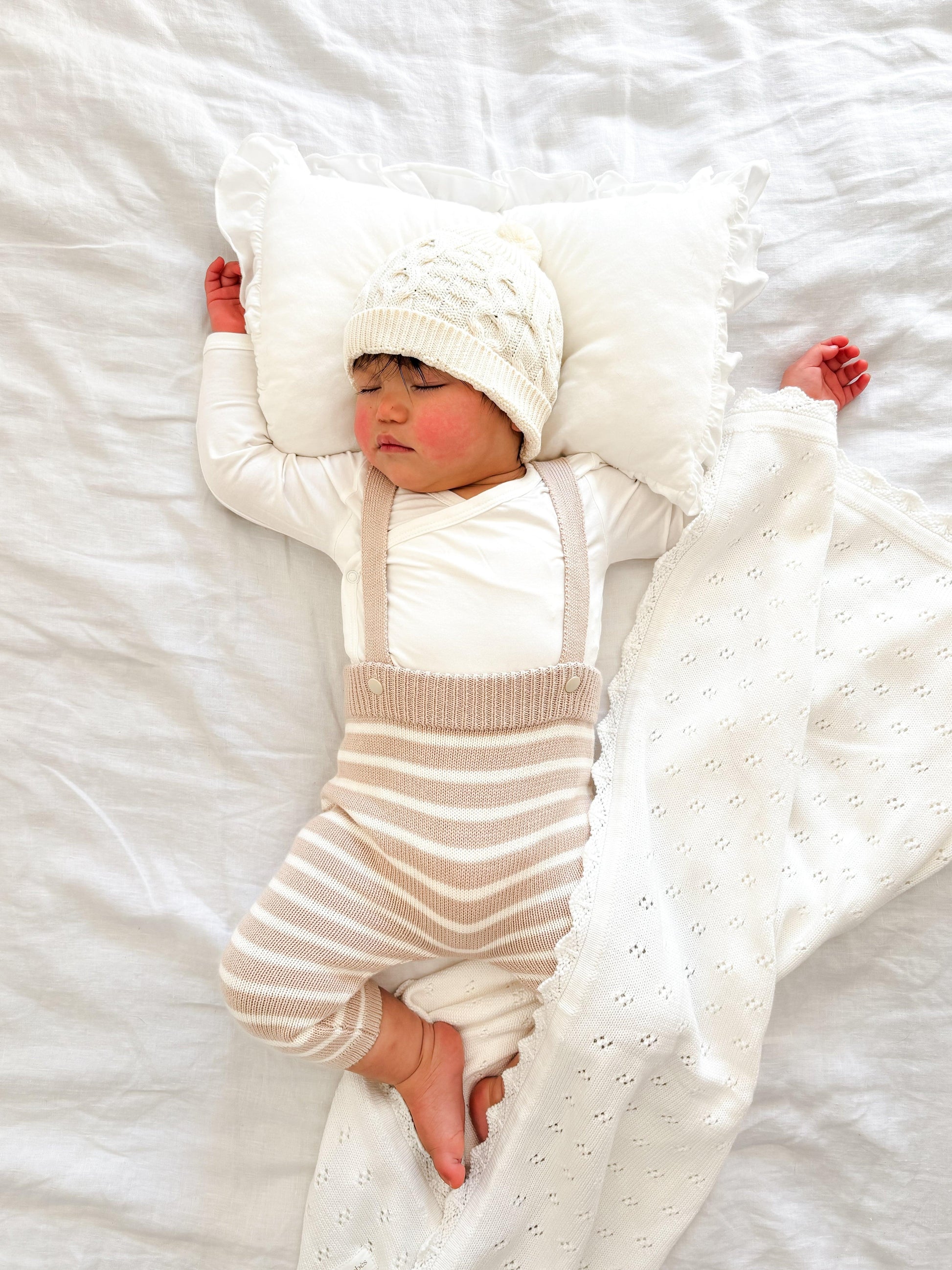 Sleeping baby wearing organic clothing wrapped in a certified organic Essentīals Crochet Blanket by Casita Bebes.