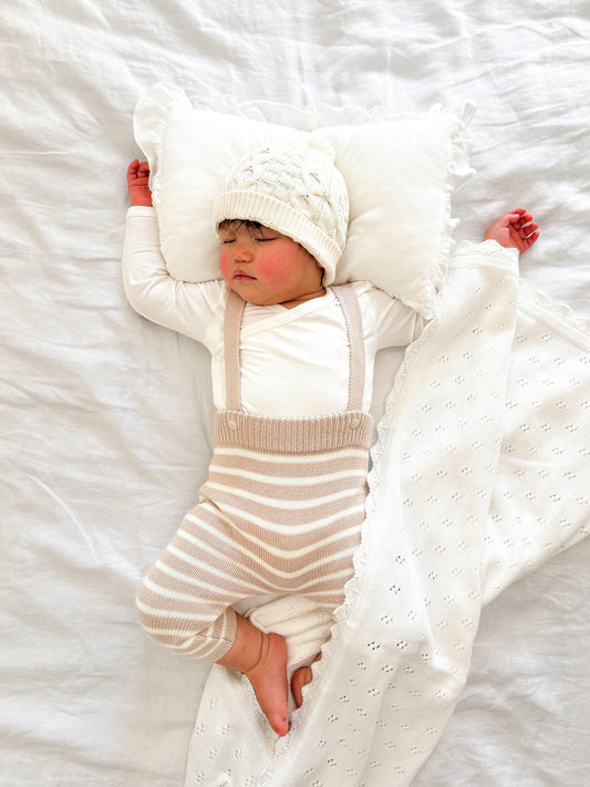 Sleeping baby wearing organic clothing wrapped in a certified organic Essentīals Crochet Blanket by Casita Bebes.