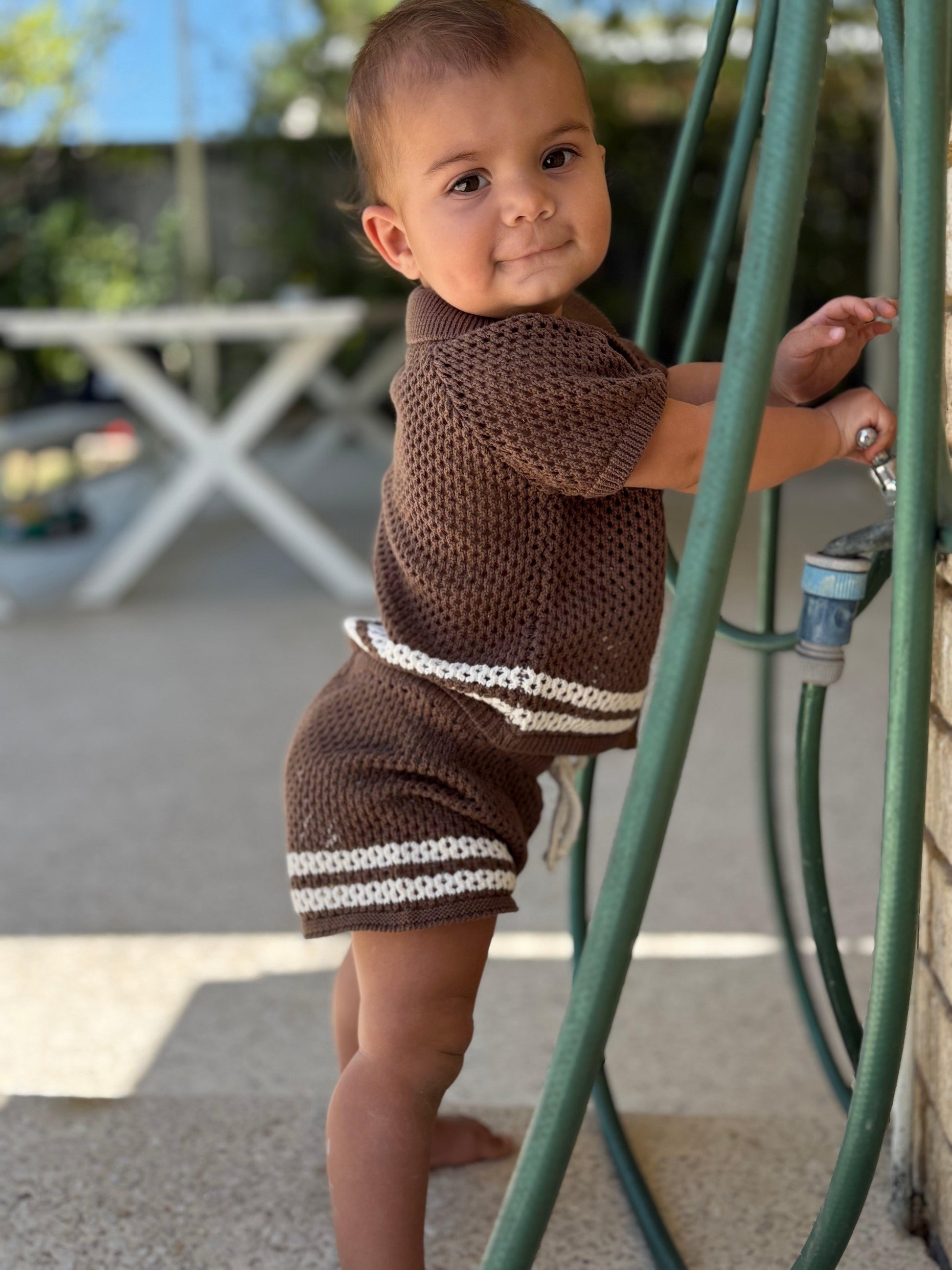 Organic dusty brown baby shorts with white stripe details, worn by standing baby, Casita Bebes certified organic baby.