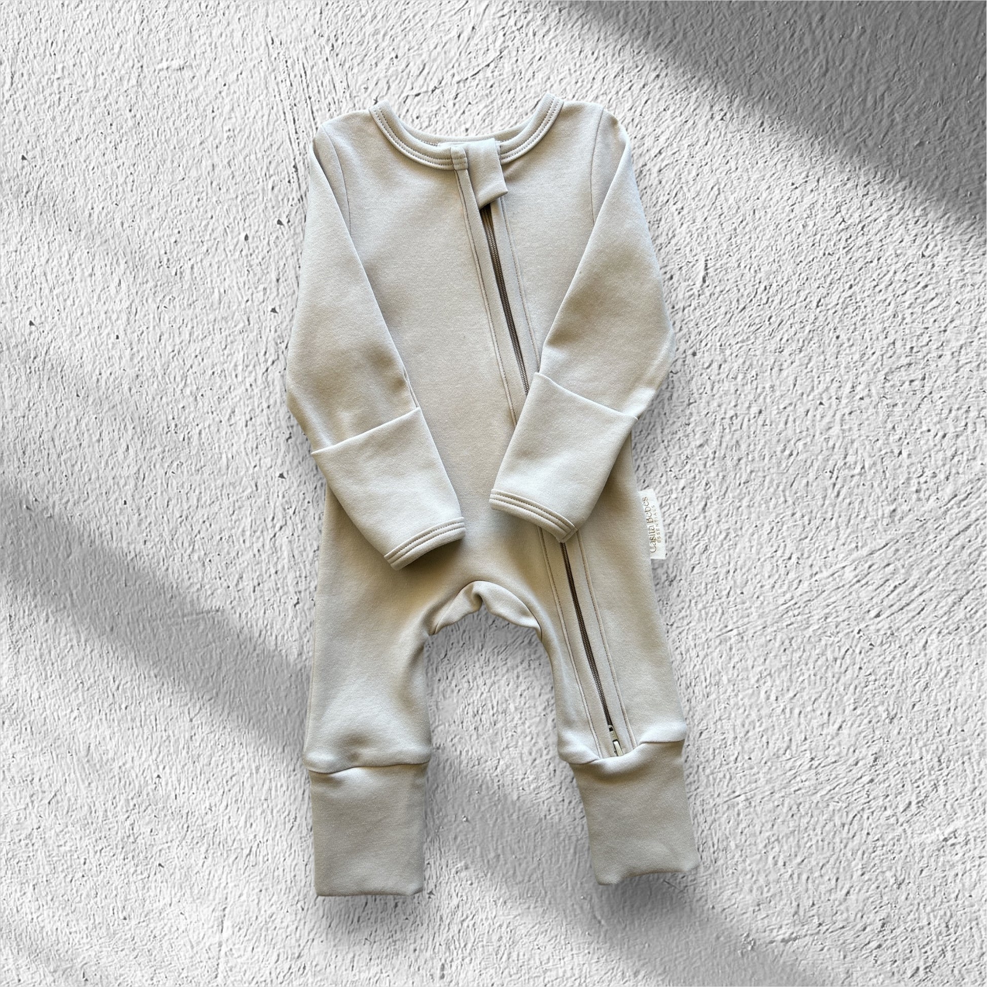 Baby new born organic cotton romper on a textured white surface