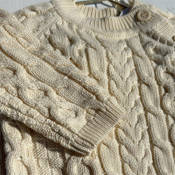 Cream cable knit baby sweater with soft organic cotton texture and button closure