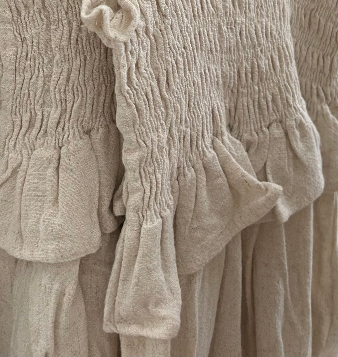 Close-up of textured beige fabric with ruffled details
