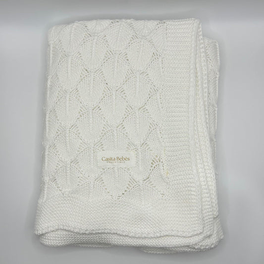 Folded knitted blanket with 'Casita Belles' branding on a gray background