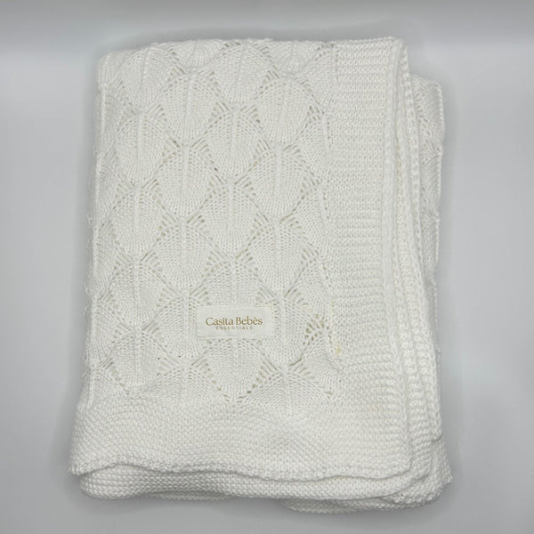Folded knitted blanket with 'Casita Belles' branding on a gray background