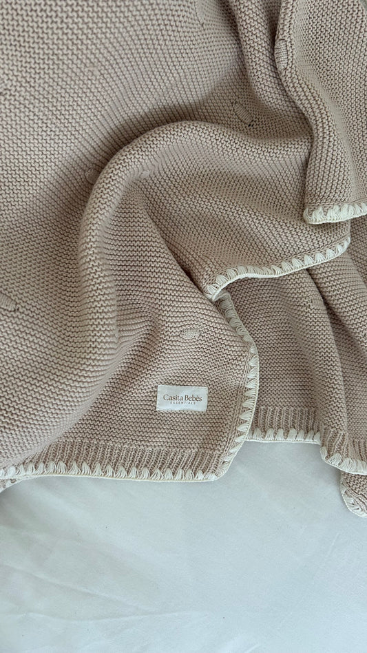 Brow Knitted blanket with a visible Casita Bebes brand label on a light background