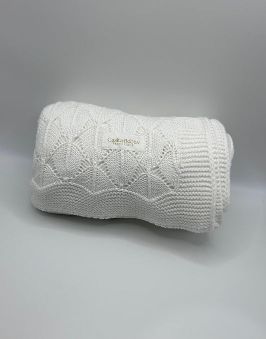 White knitted baby blanket  Casita Bebès Brand logo on a gray background