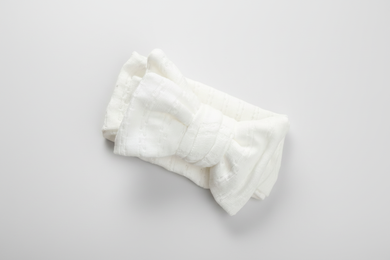 Organic white linen baby bow from Casita Bebes, certified organic fabric, soft texture.