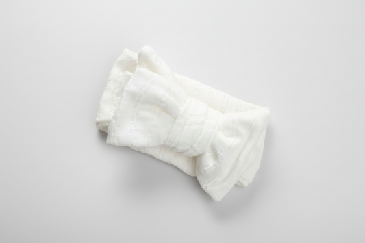 Organic white linen baby bow from Casita Bebes, certified organic fabric, soft texture.