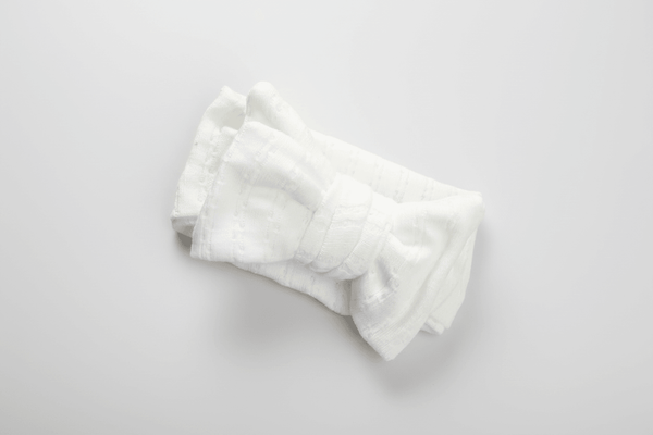 Soft white organic baby blanket with textured weave, perfect for newborns and gentle everyday use.