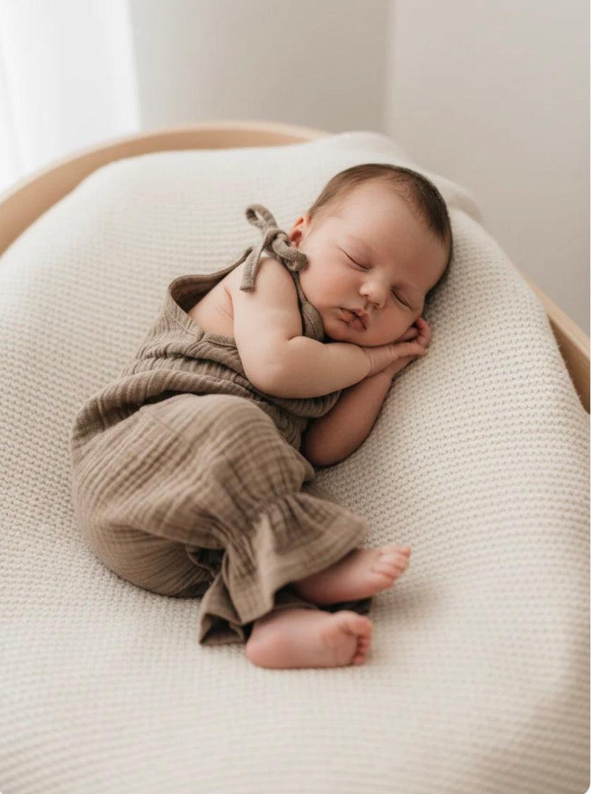 Sleeping baby wearing khaki certified organic cotton Mamīta Malani jumpsuit by Casita Bebes.