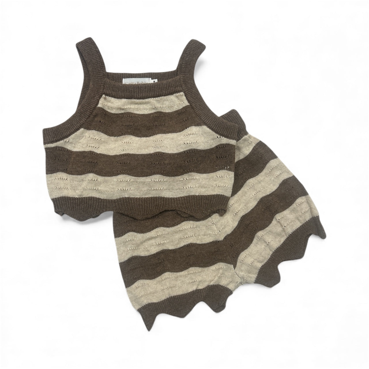 Flat lay Striped baby girl top and shorts with brown and beige stripes wavey edging on a white background