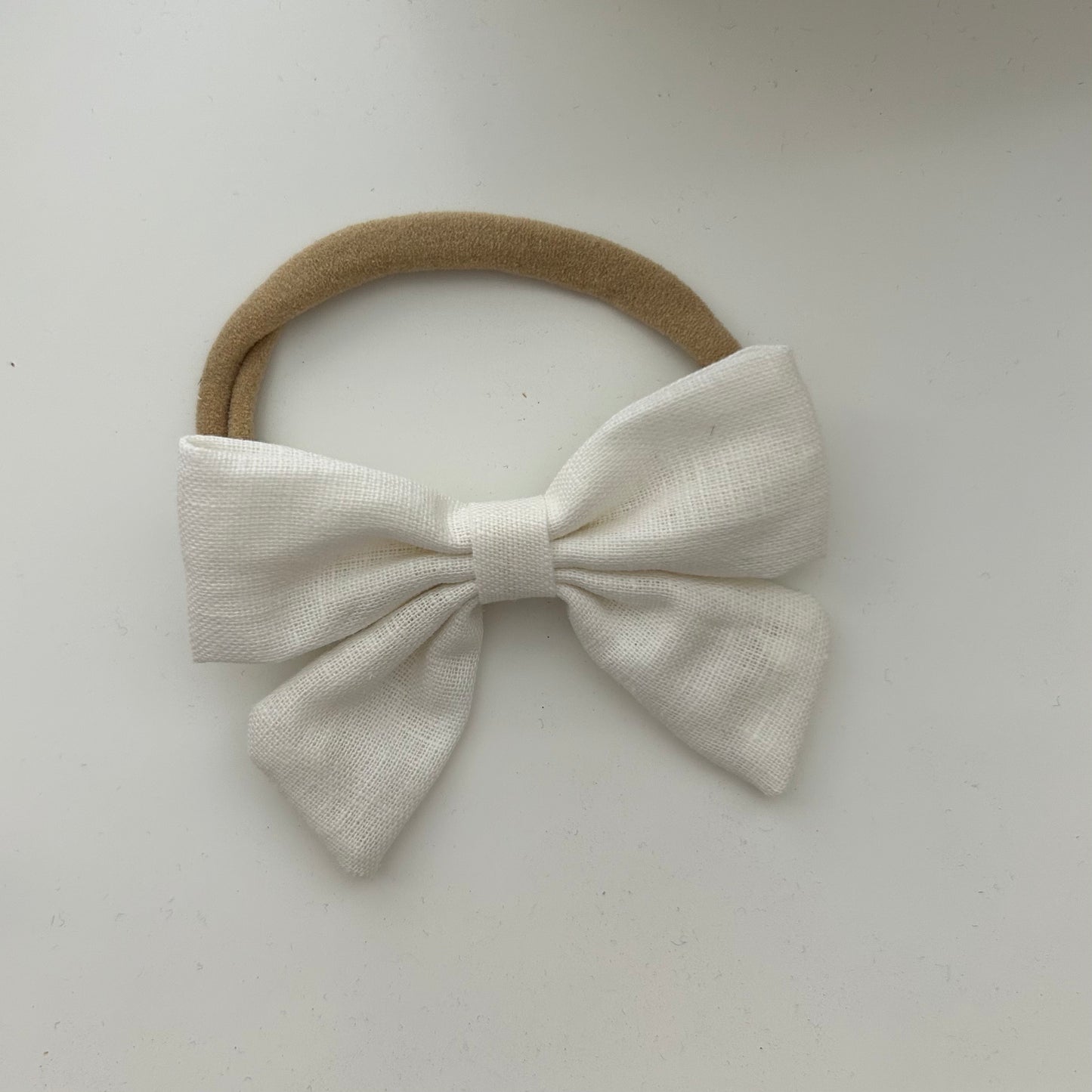 White newborn bow hair on a light gray background casita Bebès brand