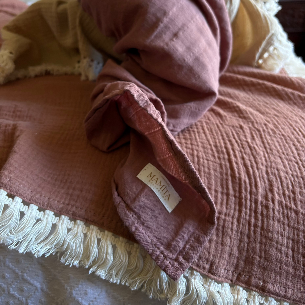 Mediterranean Tuscan Brown textured blanket with a brand label Casita Bebes on a bed