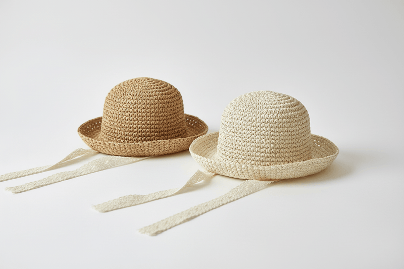 Organic baby straw hats with ribbon ties, perfect for sunny days and gentle comfort.