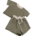 Olive green organic baby outfit with pink trim and drawstring shorts