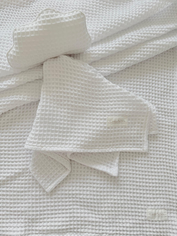 Organic white waffle knit baby comforter and matching hat from Casita Bebes, certified organic baby clothing.