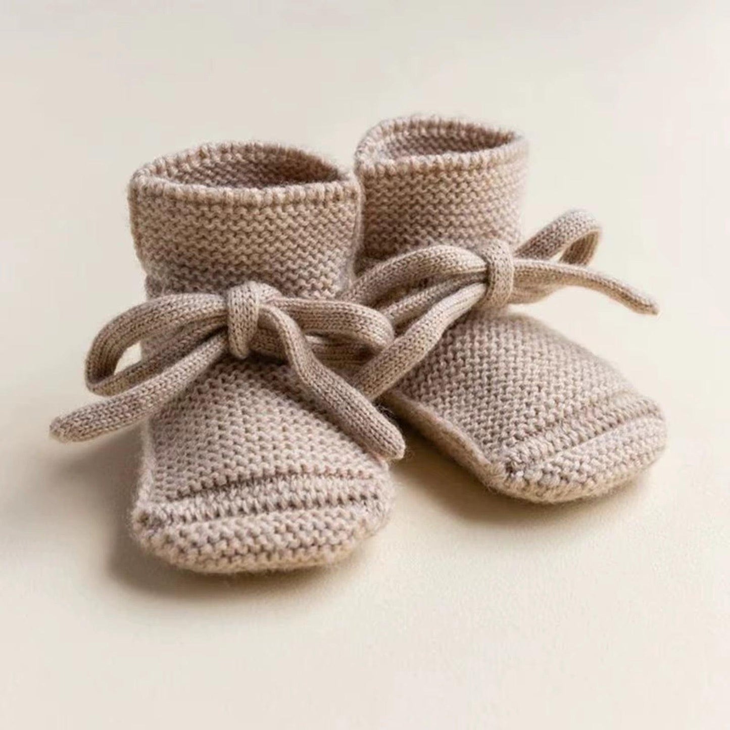 Organic dusty beige knitted baby booties with ties, certified organic baby clothing by Casita Bebes.