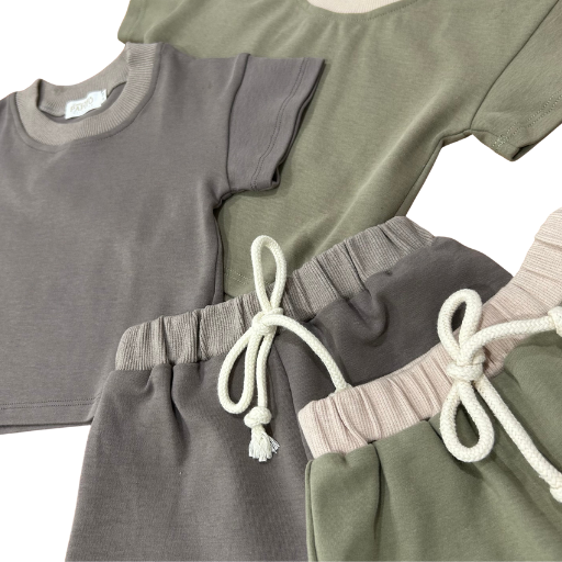 Organic dusty green and gray toddler shorts with adjustable drawstrings, soft certified fabric.