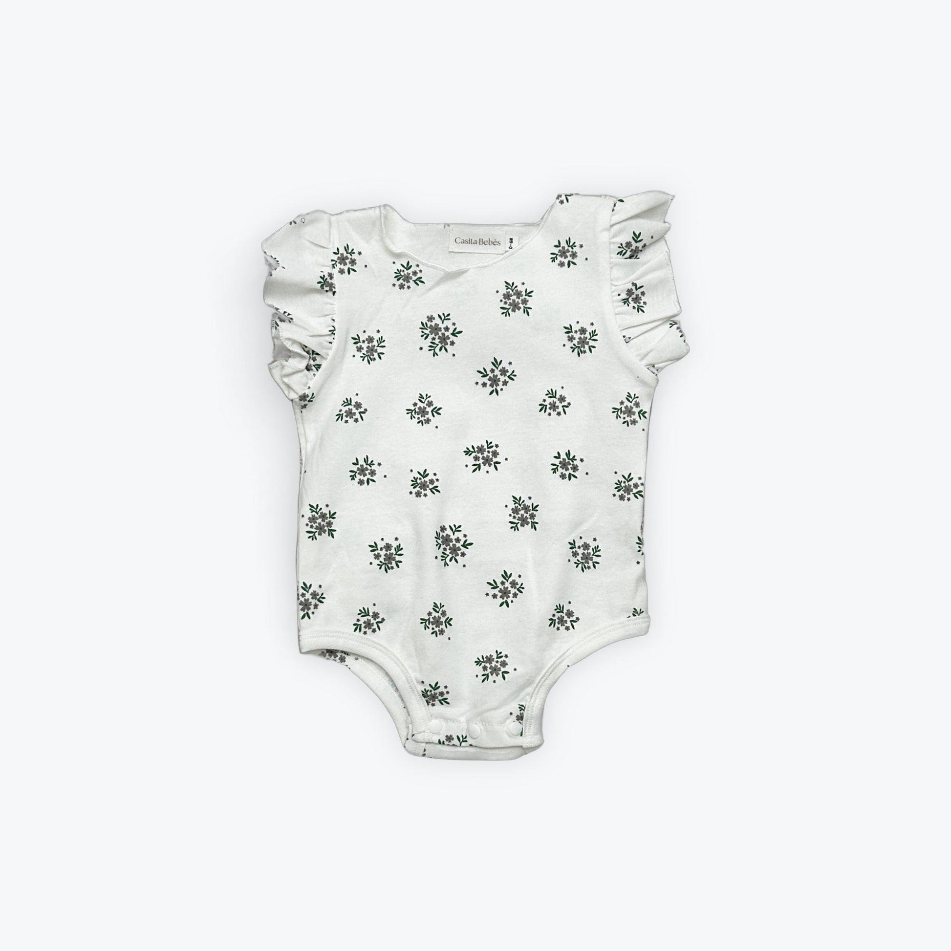 White organic baby bodysuit with green floral print and ruffled sleeves, certified organic by Casita Bebes.