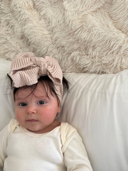 Baby wearing dusty rosa knitted bow headband, organic baby clothing by Casita Bebes, certified organic.