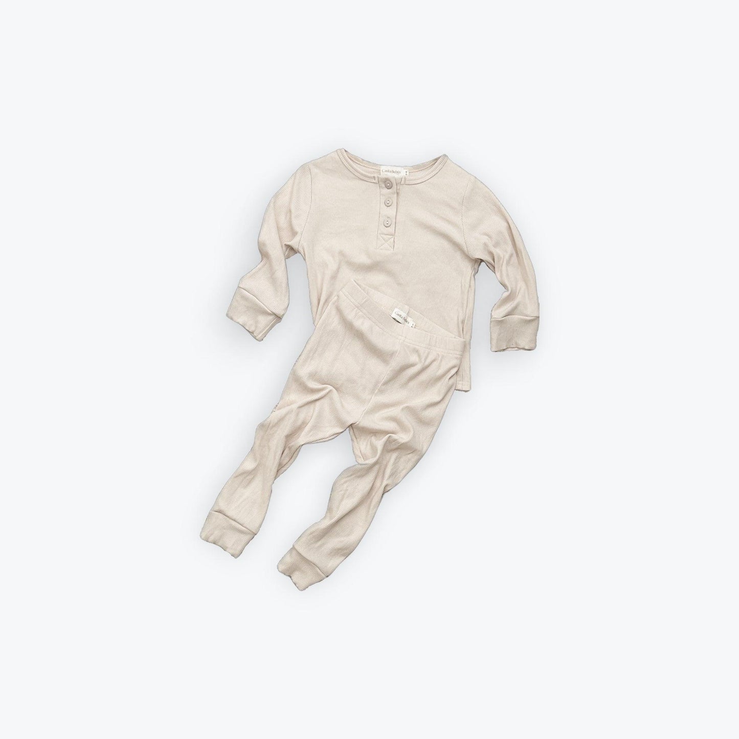 Beige organic baby sleepwear with long sleeves and snap buttons, certified organic baby clothing by Casita Bebes.