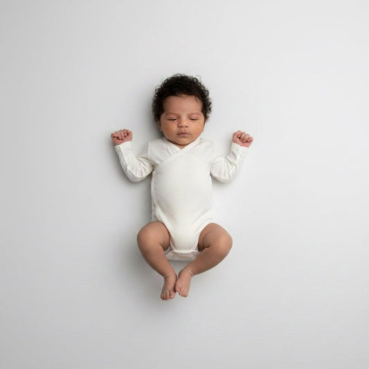 Toddler wearing organic bamboo wrap bodysuit in cream, soft baby clothing by Casita Bebes.