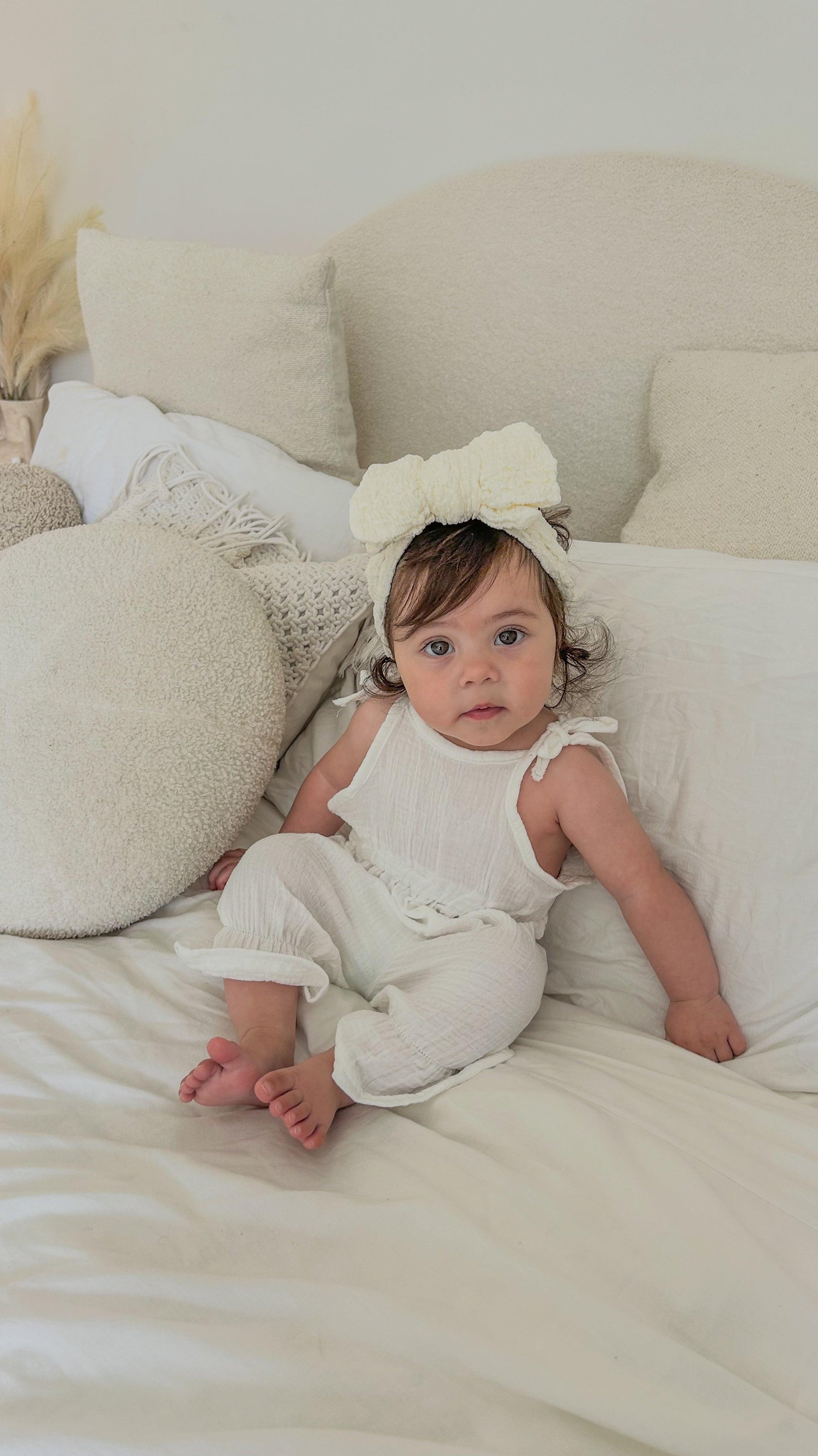 Organic white cotton jumpsuit with ruffle sleeves on baby, certified organic baby clothing from Casita Bebes.