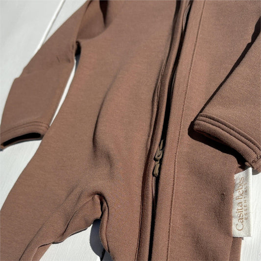 Dusty brown organic baby romper with front zipper and Casita Bebes certified organic tag.