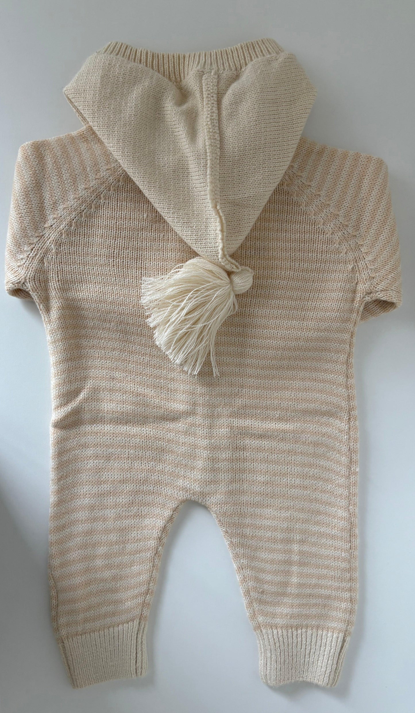 Organic baby romper with hood and tassel, soft knit design for newborns
