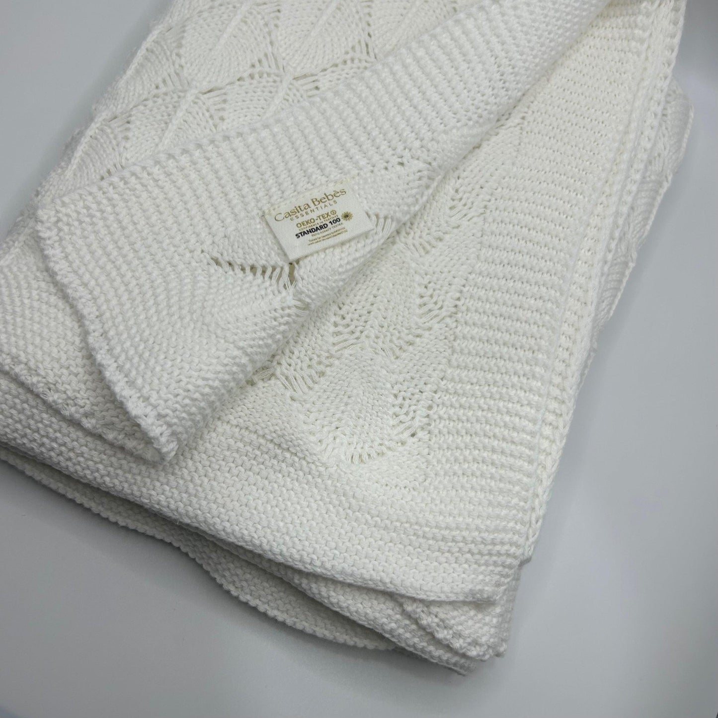 Folded baby textured blanket keko-tex standard 100 label on a light gray background