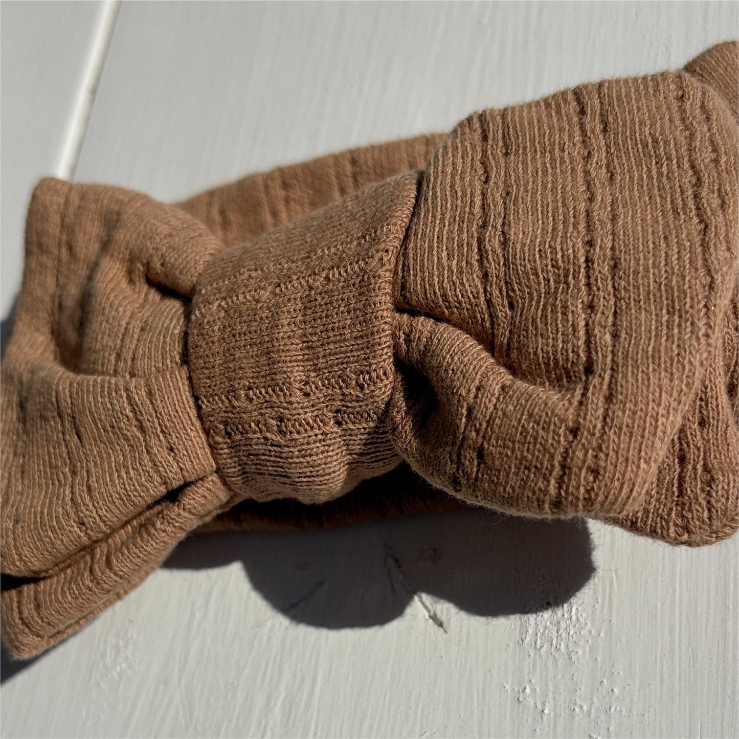 Dusty brown organic linen baby headband with textured bow from Casita Bebes Essentials Collection.