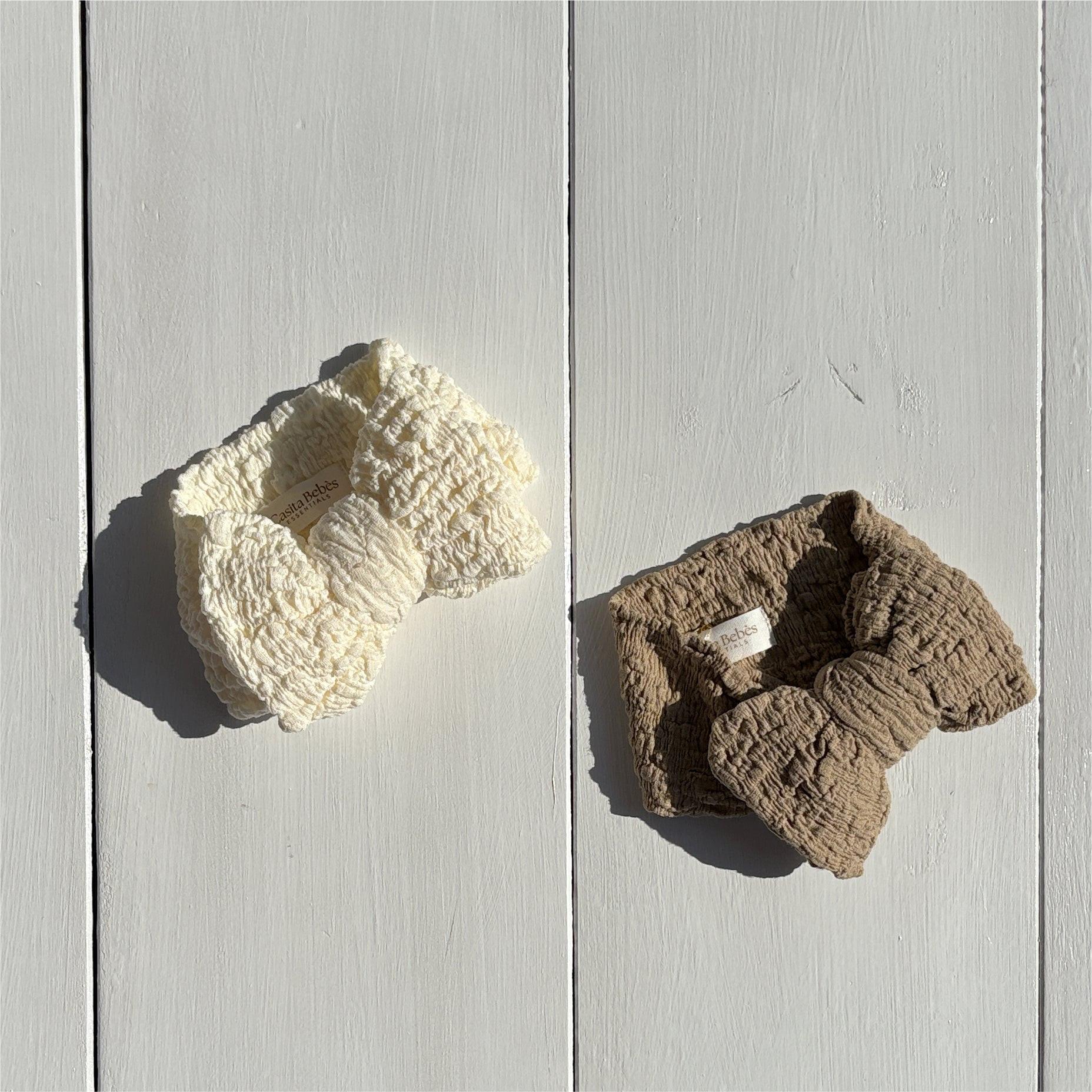 Two organic textured bow headbands for baby clothing in dusty white and dusty khaki by Casita Bebes.