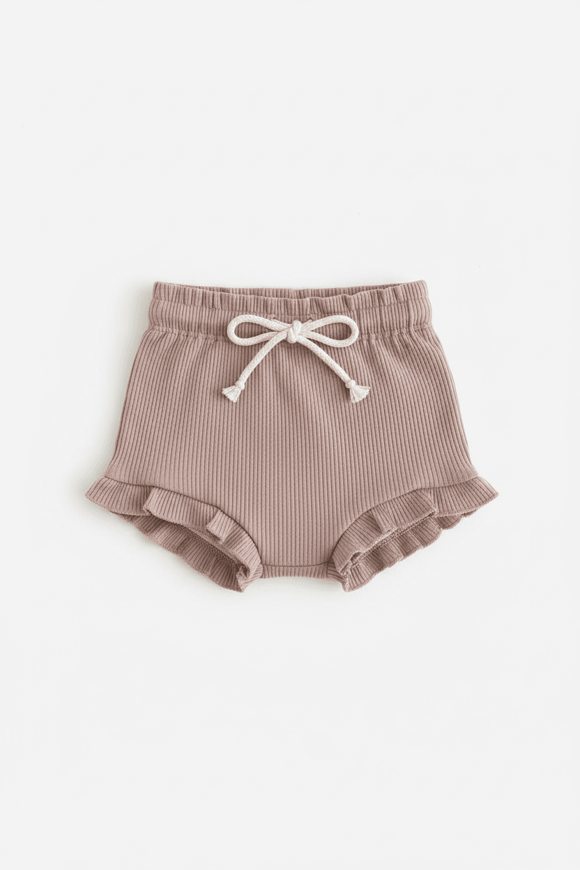 Soft ribbed baby bloomers with ruffled hem and drawstring waist, ideal for everyday comfort.