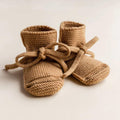 Knitted baby booties with soft ties, perfect for newborns and organic baby essentials
