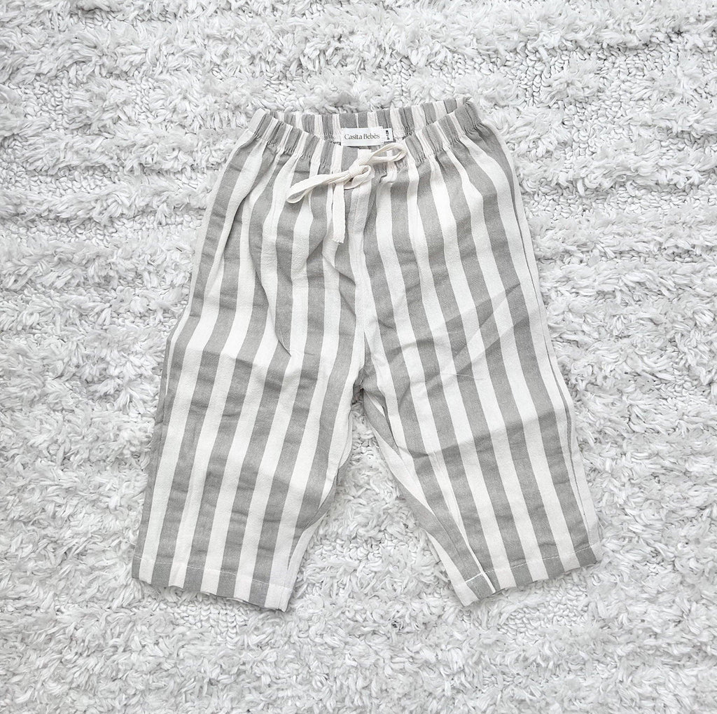 Gray and white striped baby pants on soft rug, organic cotton comfort